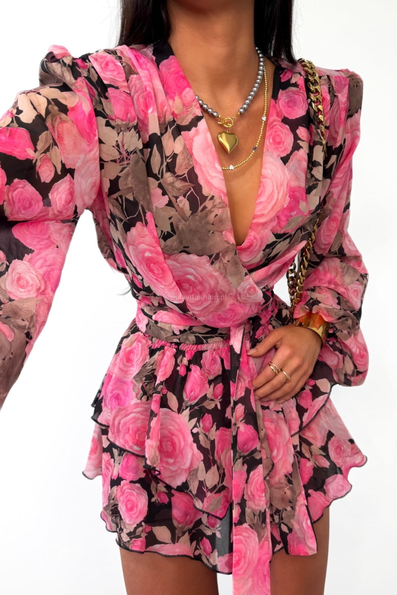 Komplet LaMilla uszyty z delikatnego materiału ozdobionego wzorem kwiatowym. Koszula posiada wszyte w ramionach poduszki i długie szarfy do przewiązania w pasie. Spódniczko spodenki posiadają na dole dziewczęce falbanki.