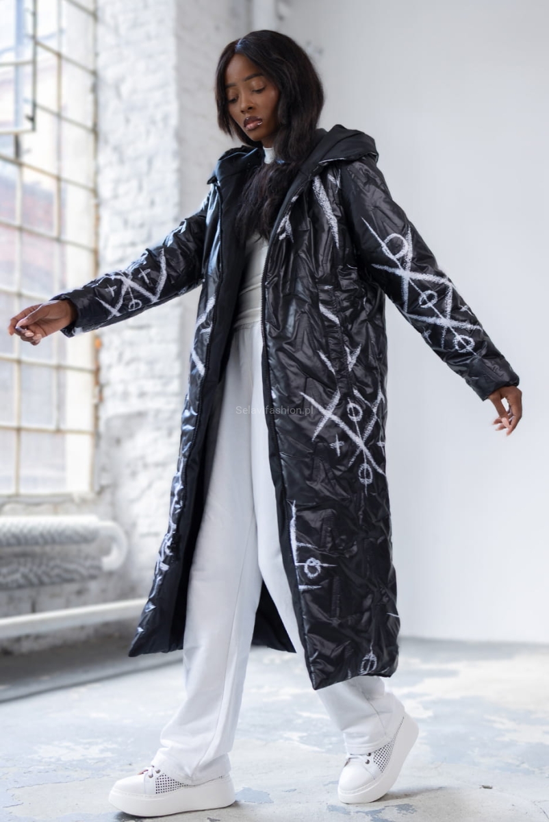 Długa dwustronna czarna kurtka XO polskiej firmy LaDonna. Zapinana na podwójny suwak. Posiada dwie klasyczne kieszenie i duży, obszerny kaptur. Materiał wyróżnia się ciekawym wzorem nadającym kurtce niepowtarzalny wygląd.