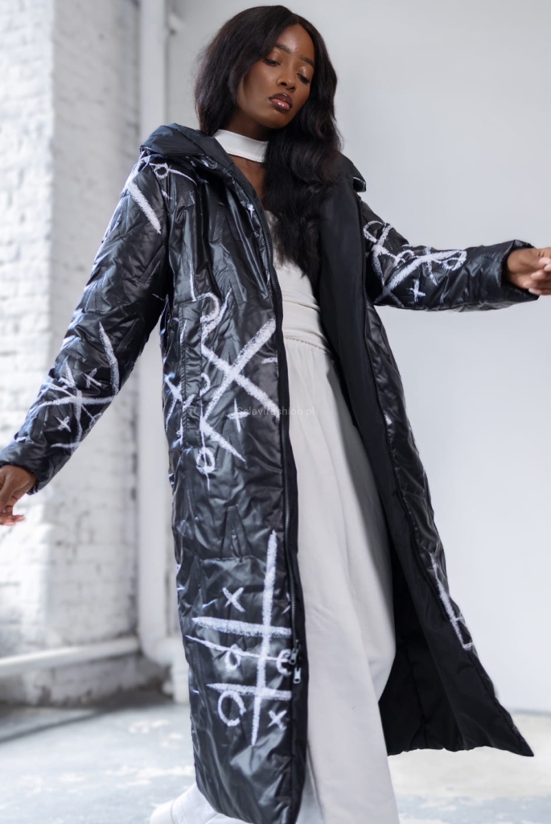 Długa dwustronna czarna kurtka XO polskiej firmy LaDonna. Zapinana na podwójny suwak. Posiada dwie klasyczne kieszenie i duży, obszerny kaptur. Materiał wyróżnia się ciekawym wzorem nadającym kurtce niepowtarzalny wygląd.