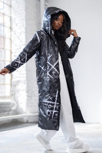Długa dwustronna czarna kurtka XO polskiej firmy LaDonna. Zapinana na podwójny suwak. Posiada dwie klasyczne kieszenie i duży, obszerny kaptur. Materiał wyróżnia się ciekawym wzorem nadającym kurtce niepowtarzalny wygląd.