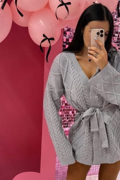 Wełniany, krótki kardigan szary od LaMilla z długim rękawem i paskiem. Dzianina posiada piękny geometryczny wzór zdobiący sweter.