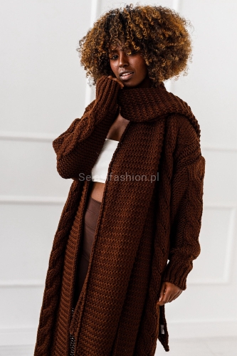 Ten efektowny kardigan o długości maxi od Miss City to idealne połączenie wygody i stylu street. Wykonany z ciepłej, miękkiej dzianiny, zachwyca grubszą teksturą. Sweter jest w komplecie z szalikiem.