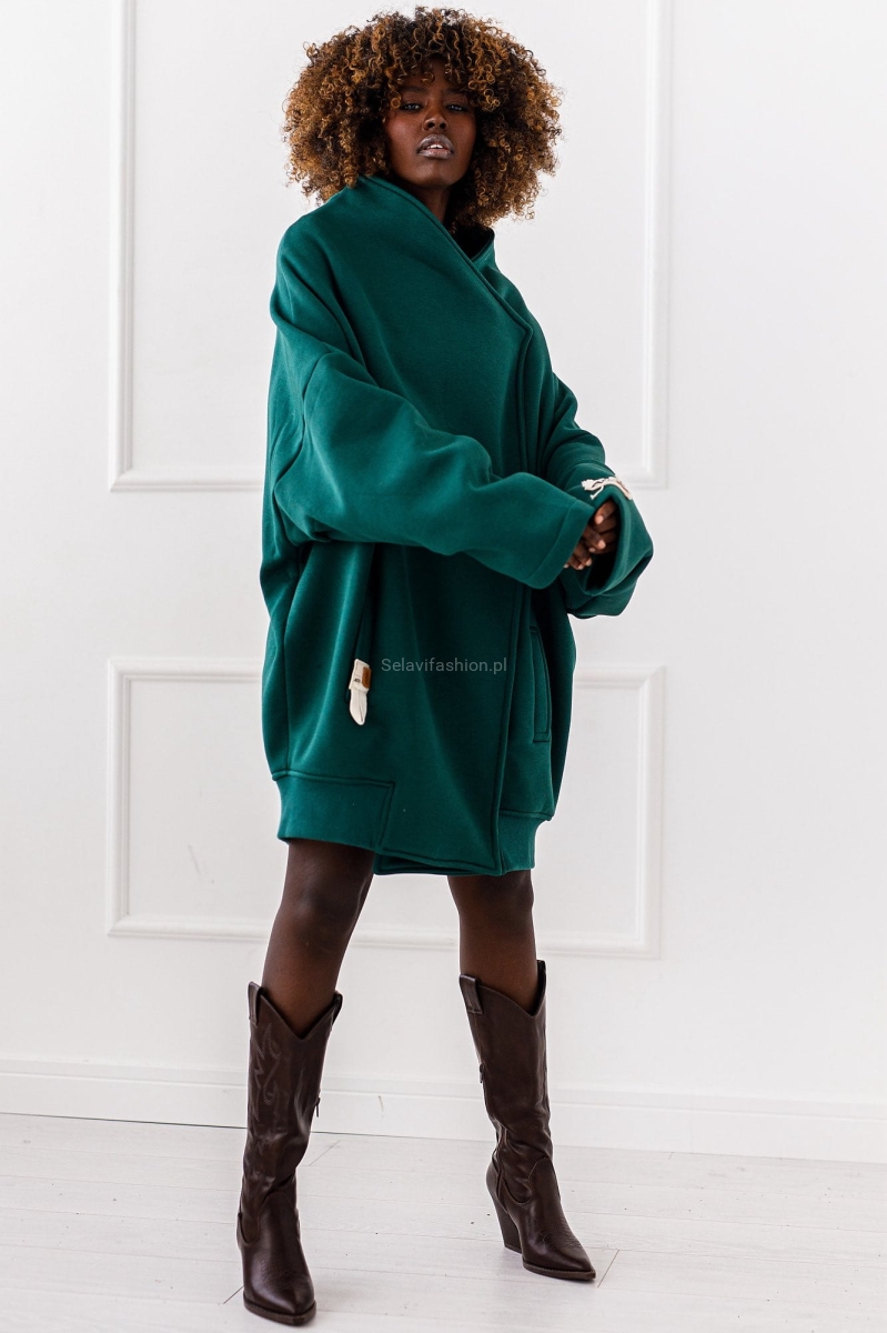 Długa bluza dzianinowa w kolorze zielonym o asymetrycznym kroju, zapinana na zatrzaski. Fason kimono ze stójką.