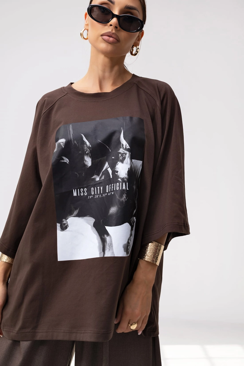 T-shirt Doberman o pudełkowym kroju posiada luźną, oversize’ową formę z przedłużonymi rękawkami do łokcia, co nadaje mu nowoczesny, sportowy wygląd. Duży nadruk, w formie grafiki stanowi główny element przyciągający uwagę.