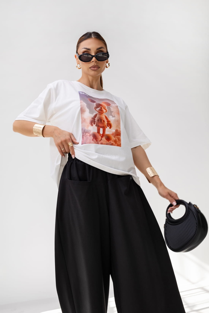 T-shirt Energy Miki ma luźny, oversize’owy krój i krótki rękaw. Wykonany jest z lekkiej bawełny. Na przodzie znajduje się duży nadruk – grafika w stylu 3D. Koszulka ma prosty fason, klasyczny dekolt pod szyję i pasuje zarówno do casualowych