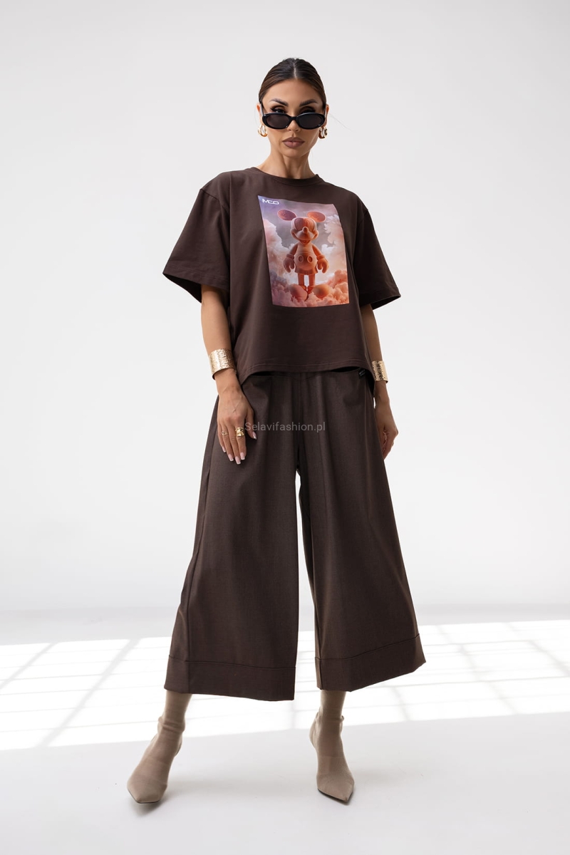 T-shirt Energy Miki ma luźny, oversize’owy krój i krótki rękaw. Wykonany jest z lekkiej bawełny. Na przodzie znajduje się duży nadruk – grafika w stylu 3D. Koszulka ma prosty fason, klasyczny dekolt pod szyję i pasuje zarówno do casualowych